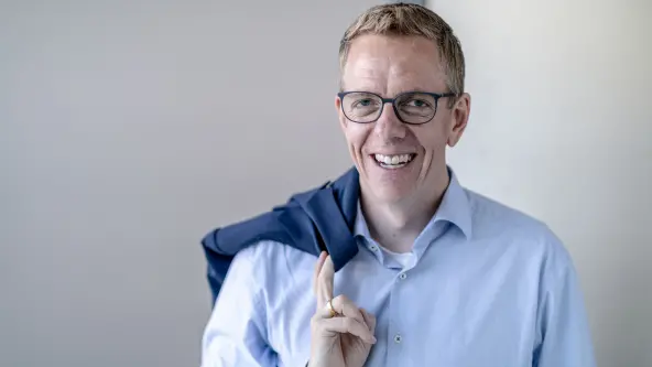 Harald Rosenberger, Vorstand der NÜRNBERGER Versicherung lächelt und hat Blazer über Schulter geworfen