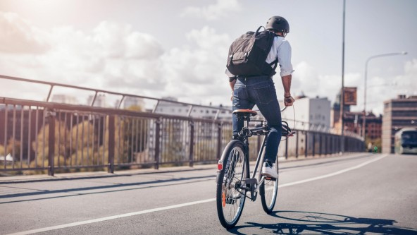 Mann fährt mit Fahrrad auf einer Straße