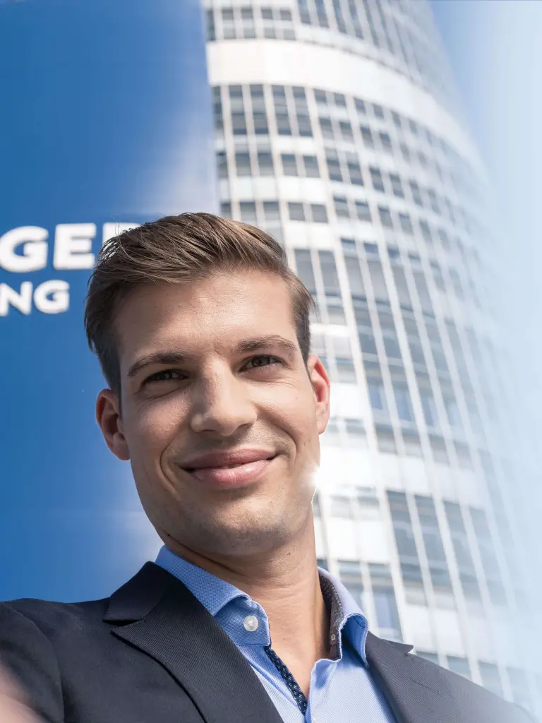 Junger Mann blickt leicht schmunzelnd in die Kamera