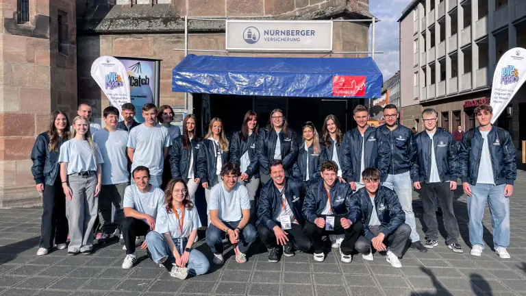 Junge Menschen stehen vor einem Verkaufsstand