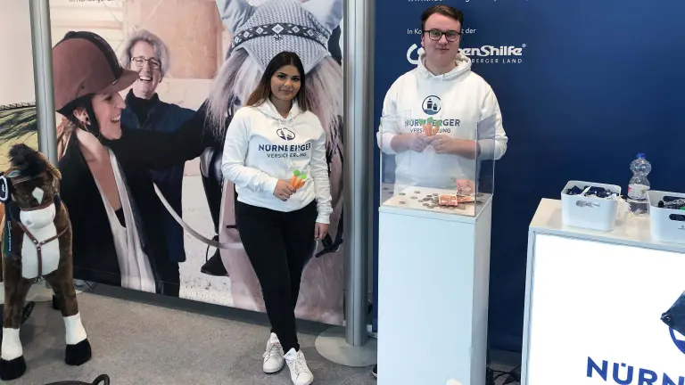Mann und Frau stehen vor einem Informationsstand 