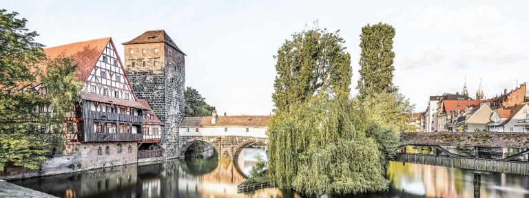 Blick auf Fluss und eine alte Steinbrücke in Nürnberg