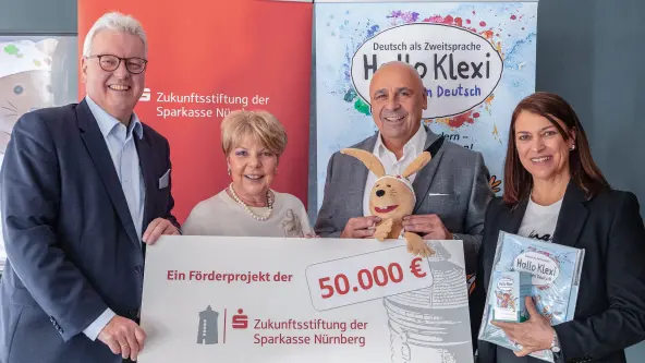 2 Männer und 2 Frauen halten einen großen Spendenscheck in der Hand