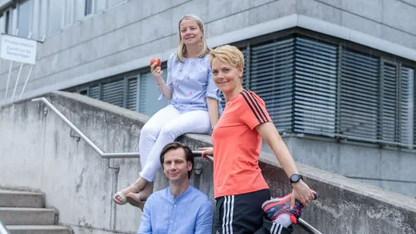 2 junge Menschen sind auf einer Treppe und schauen in die Kamera