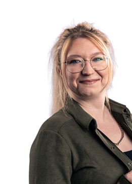 Frau mittleren Alters mit rotem langen Haar, die Frau trägt einen grüne Bluse.